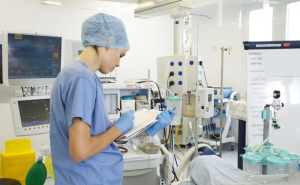 Anaesthetist in theatre making notes