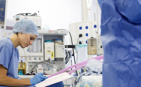 Anaesthetist updating chart in theatre