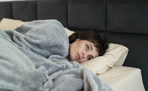 Image of tired and exhausted woman in bed
